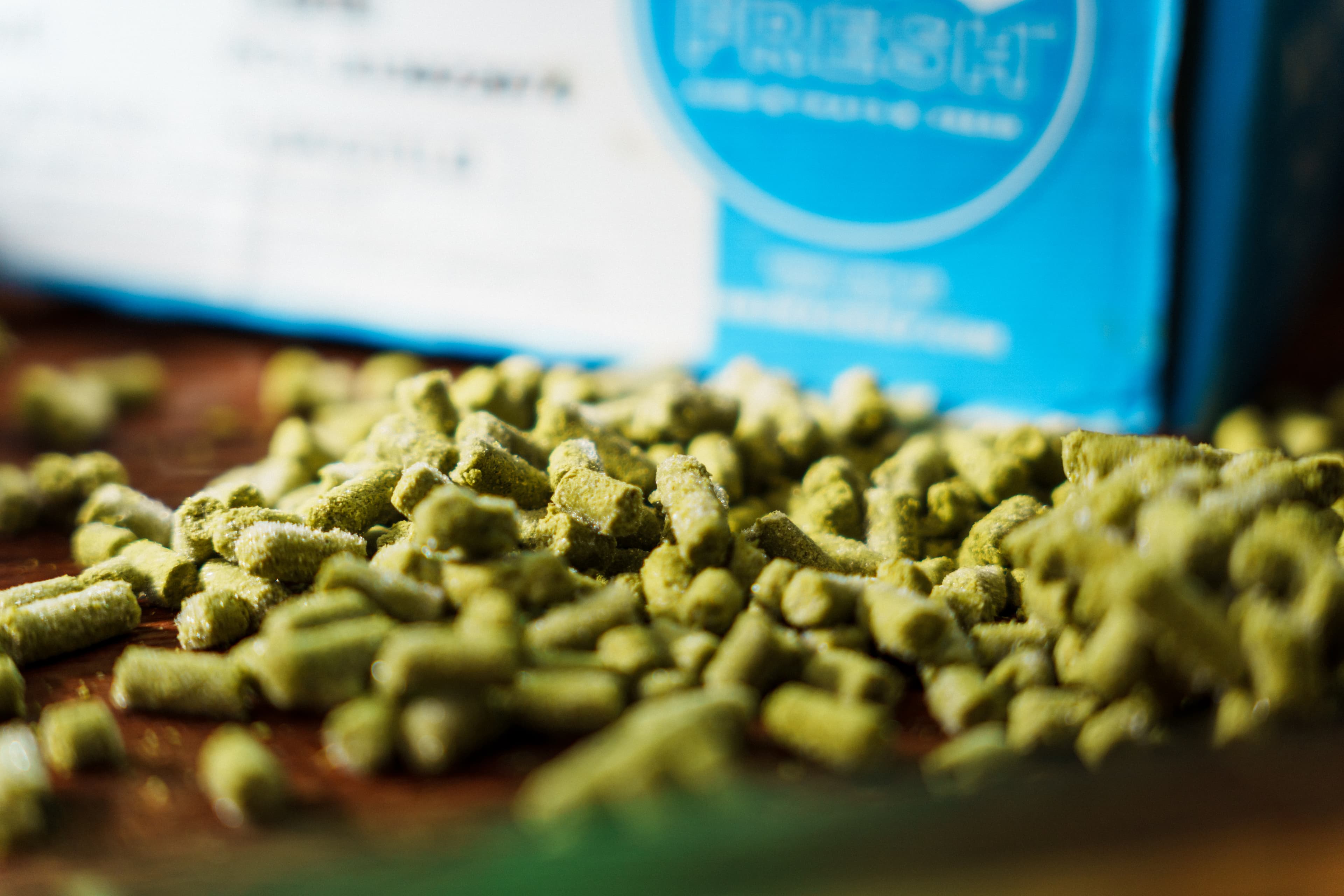 Frosty green hop pellets piled in front of YCH Cryo Fresh box