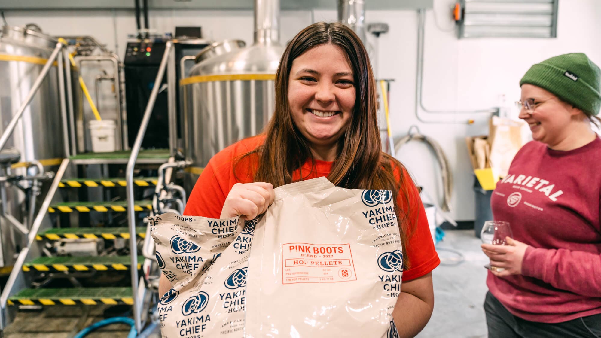 Woman holding bag of Pink Boots Blend hops and smiling