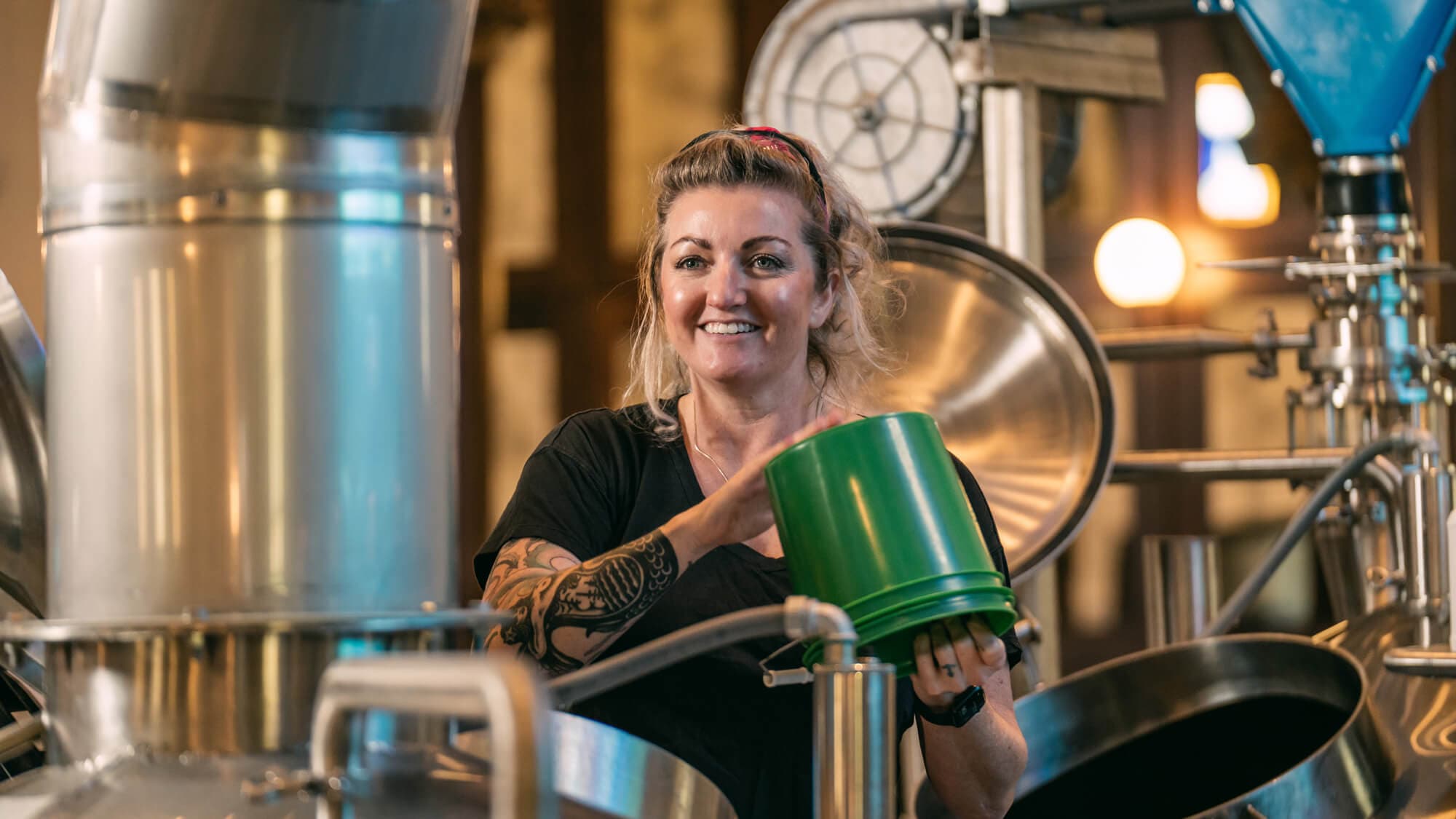 Brewer smiles for a photo while holding a bucket