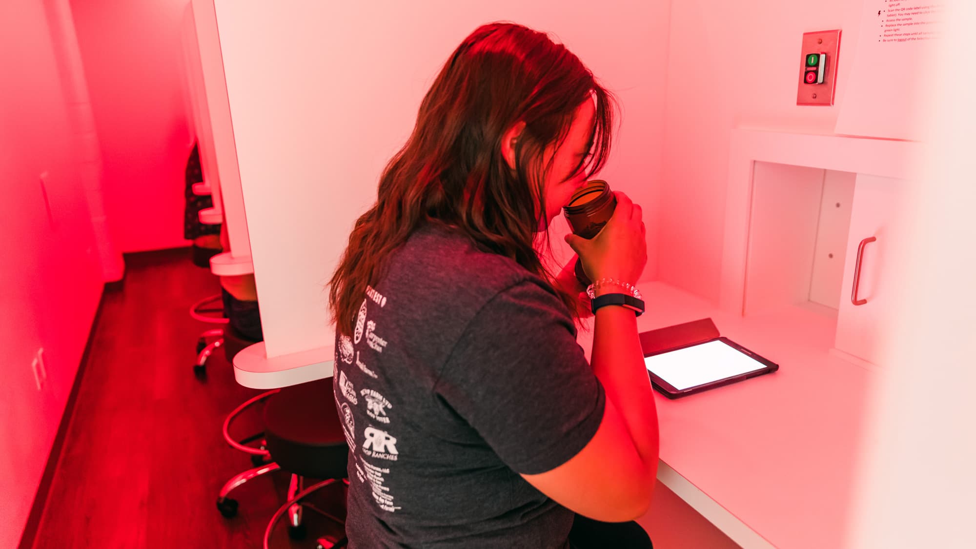 Sensory panelist smells hop sample in red light sensory booth