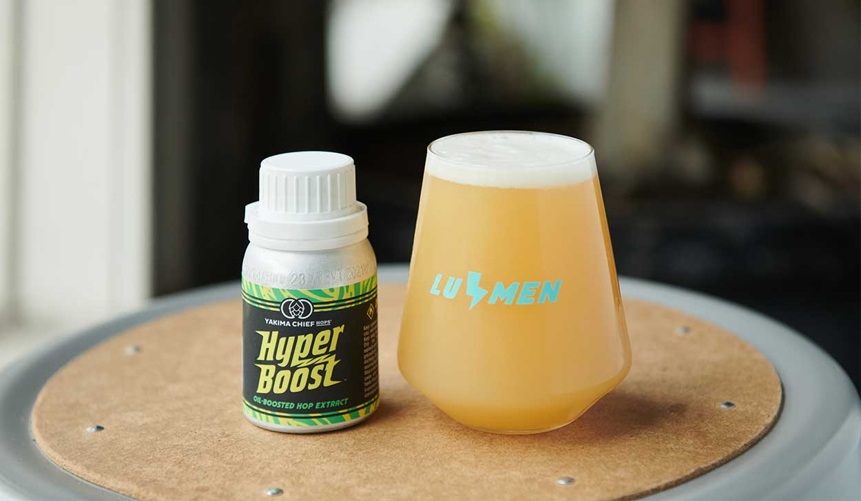 Hyperboost container and beer in a glass labeled lumen