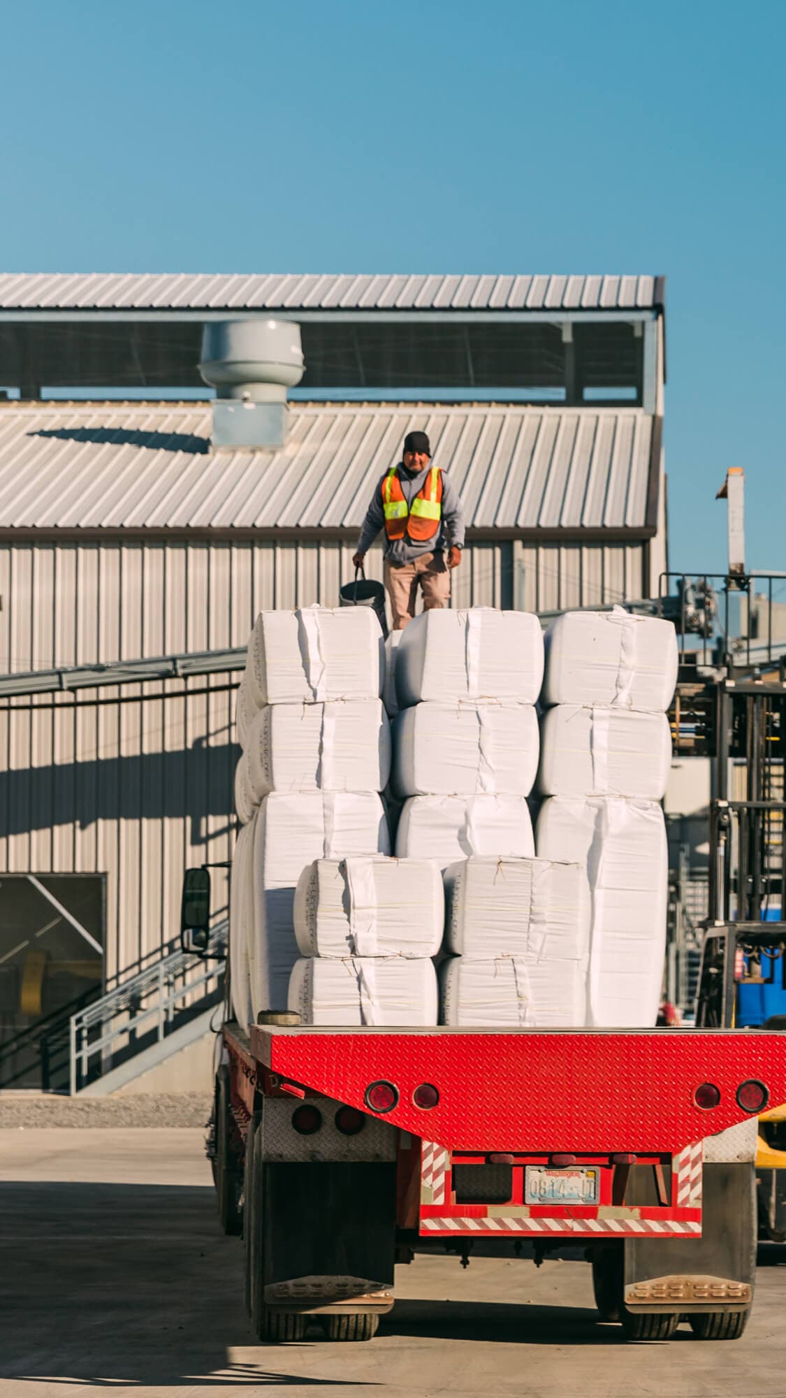 Image of a man loading hop bales onto truck